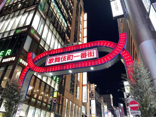 東京的住宿－HOTEL AMANEK Shinjuku Kabukicho，建筑中间的一个红色大标志