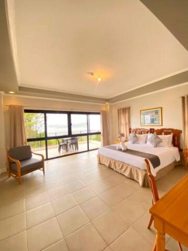 a large bedroom with a bed and a large window at Alegria 1E in Kababae