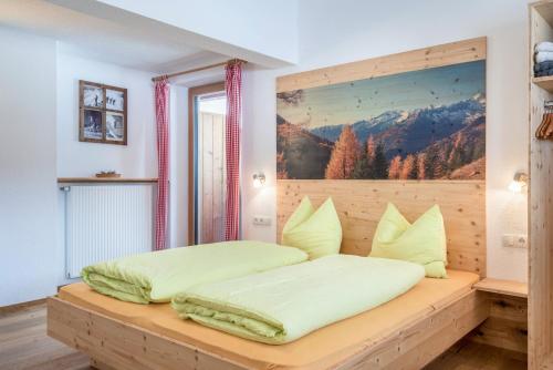 een bed in een kamer met een foto aan de muur bij Mountainfarm Innertrein Jöchl in Cadipietra
