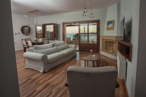 a living room with a couch and a table at Elounda Maris Villas in Elounda