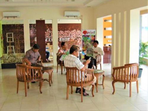 a group of people sitting at tables in a restaurant at Citra Raya Hotel Banjarmasin in Banjarmasin
