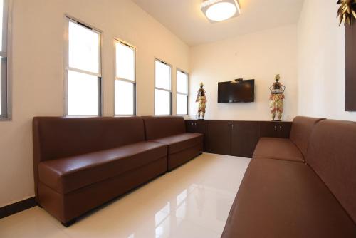 a living room with a couch and a flat screen tv at Hotel Soneva Inn in Rānchī