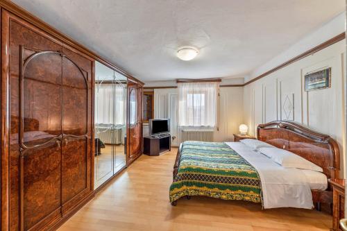 Appartamento Pisani في Brez: غرفة نوم بسرير كبير وتلفزيون