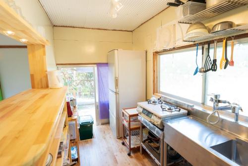 une cuisine avec évier et cuisinière ainsi qu'une fenêtre dans l'établissement Hide A Way - Vacation STAY 90104v, à Nishinoomote