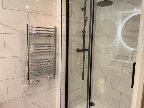 a bathroom with a shower with a glass door at My London Holiday Home in Woolwich