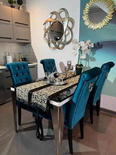 a dining room with a table and blue chairs at Apartament 308 in Świnoujście