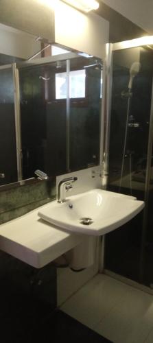 a bathroom with a white sink and a mirror at Hotel Coconut Bar Sea Lodge in Beruwala