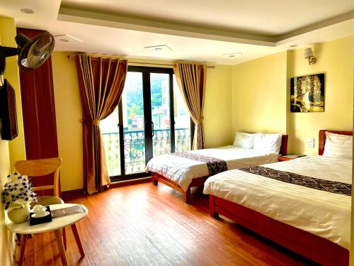 a hotel room with two beds and a window at ChiChi Hotel Sapa in Sapa