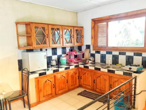 cocina con armarios de madera, fregadero y ventana en Galkotuwa Estate en Gelioya