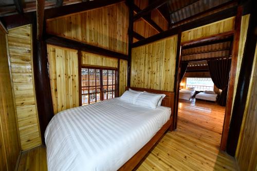 a bedroom with a bed in a room with wooden walls at Sapa Fantasea Homestay in Sapa