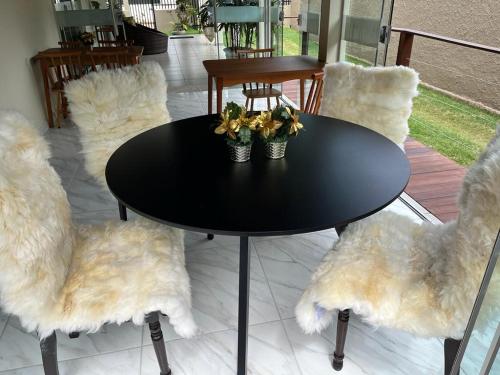 a black table and chairs with flowers on it at POUSADA ACONCHEGO MT in Chapada dos Guimarães
