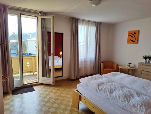 a bedroom with a bed and a sliding glass door at Uptown Apartments Interlaken free Parking in Interlaken