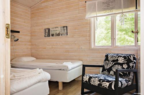 托雷哥夫的住宿－First Camp Torekov-Båstad，客房设有两张床、一把椅子和窗户。