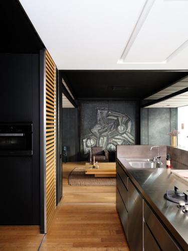 a kitchen with a sink and a bedroom in the background at CE RESIDENCE in Ghent
