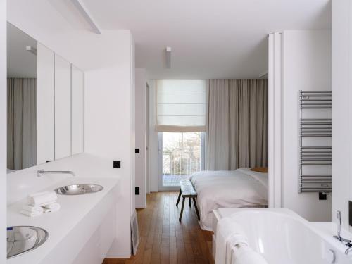 un bagno bianco con due lavandini e un letto di CE RESIDENCE a Gand