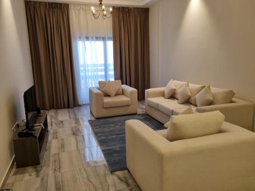 a living room with two couches and a television at Grand Stay Holiday Homes Al Jaddaf in Dubai
