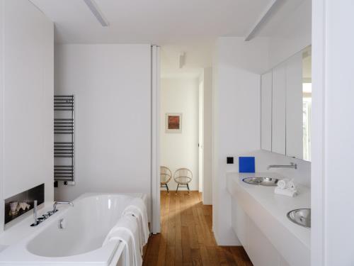 Baño blanco con 2 lavabos y bañera en CE RESIDENCE, en Gante