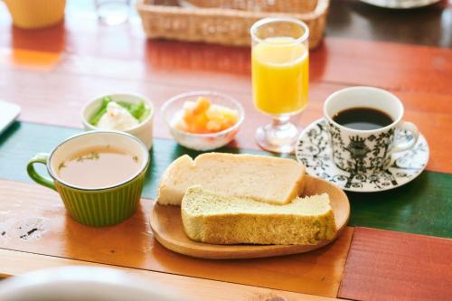 a table with a sandwich and two cups of coffee and orange juice at Vacation House Familia in Kōzushima
