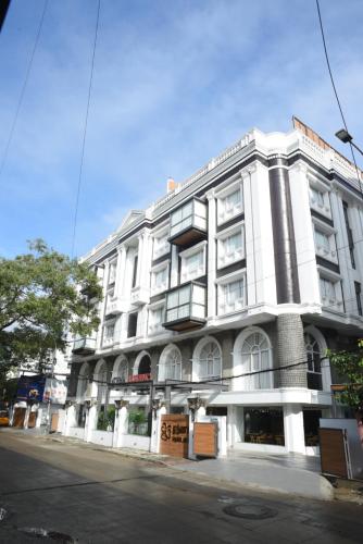 a white building on the corner of a street at RATHNA RESIDENCY - Near US CONSULATE in Chennai