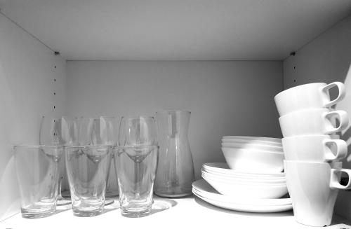 a group of glasses and plates and bowls on a shelf at Konopnickiej 88 Cosy Apartment in Sosnowiec