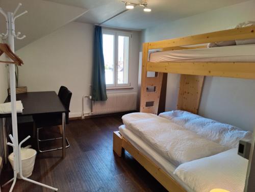 Un dormitorio con dos literas y un escritorio. en Uptown Apartments Interlaken free Parking, en Interlaken