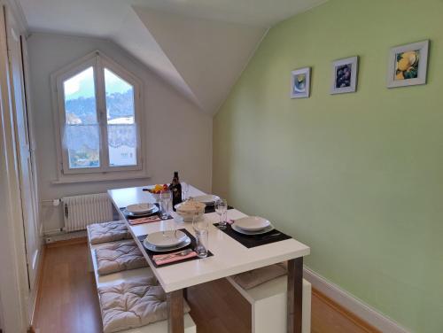 a dining room with a white table and a window at Uptown Apartments Interlaken free Parking in Interlaken