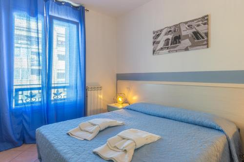 een slaapkamer met een blauw bed en handdoeken bij Residence Rialto in Trieste