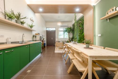 a kitchen with green cabinets and a long table at Taitung Bear Station Inn in Taitung City