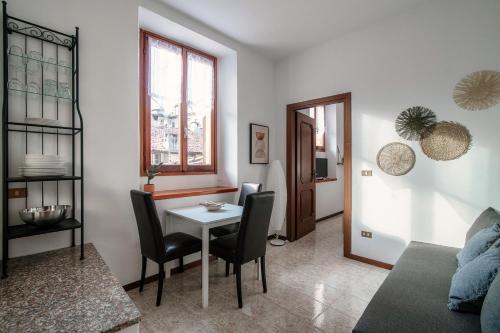 a living room with a table and chairs at Apartment Piazza Roma by Quokka 360 - historic flat in the centre of Como in Como
