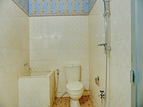 uma casa de banho com um WC e um chuveiro em OYO 92189 Wisma Inayah Syariah em Palimbão