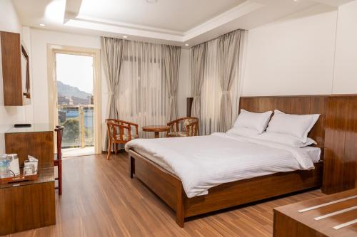 a bedroom with a bed and a table and a window at YULOKO GUEST HOUSE in Kathmandu