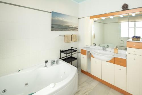 ein weißes Badezimmer mit einer Badewanne, einem Waschbecken und einer Badewanne in der Unterkunft Large Luxury Family Villa 500m To Beach in Mijas Costa