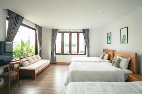 a hotel room with two beds and a tv at Kool House in Tuy Hoa
