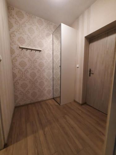 an empty room with a door and a wooden floor at Hotel Boršičanka in Havířov