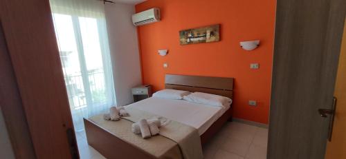 1 dormitorio con paredes de color naranja y 1 cama con toallas en Sanleoresidence Holiday Apartments In Briatico A Few Km From Tropea, en Briatico