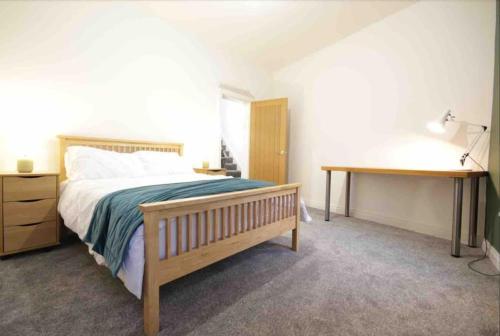 a bedroom with a large bed and a desk at Casement Townhouse in Belfast