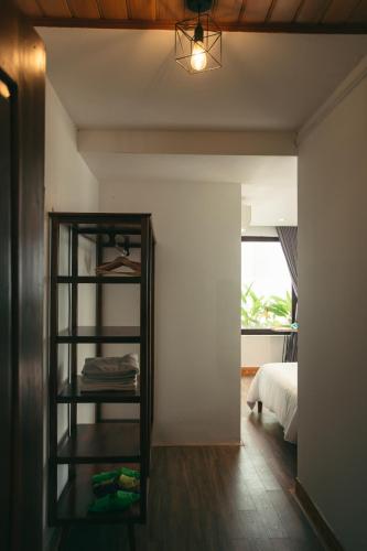 a room with a bed and a shelf with towels at Kool House in Tuy Hoa