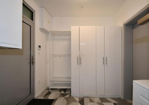 a kitchen with white cabinets and a tiled floor at EFI Residence Holzova 28 in Brno