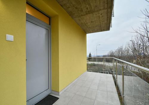 a yellow building with a door on a balcony at EFI Residence Holzova 28 in Brno