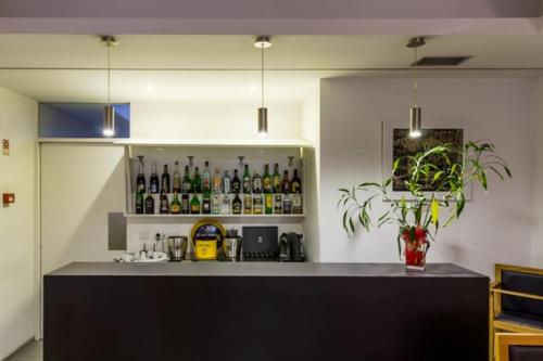 a kitchen with a bar with bottles on a shelf at Hotel Laranjeira in Viana do Castelo