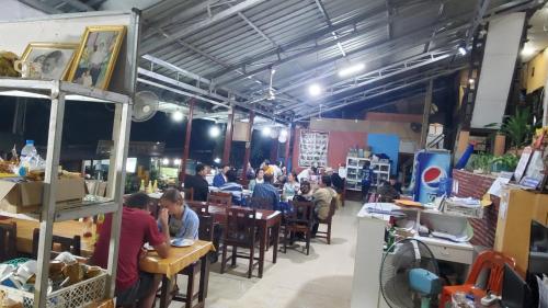 un gruppo di persone sedute ai tavoli di un ristorante di Pakbeng Guesthouse a Pakbeng