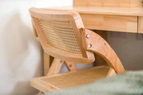 a wooden chair sitting in front of a desk at Taitung Bear Station Inn in Taitung City