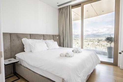 a bedroom with a large bed with two towels on it at 360 Nicosia - Luxury Apartment Panoramic View in Nicosia