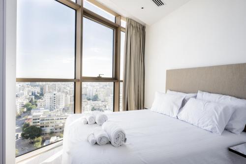 a bedroom with a white bed with towels on it at 360 Nicosia - Luxury Apartment Panoramic View in Nicosia