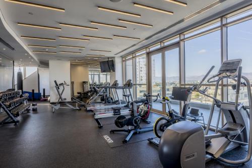 a gym with cardio equipment in a building with windows at 360 Nicosia - Luxury Apartment Panoramic View in Nicosia