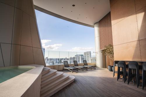 - un balcon avec des chaises et une piscine dans un bâtiment dans l'établissement 360 Nicosia - Luxury Apartment Panoramic View, à Nicosie