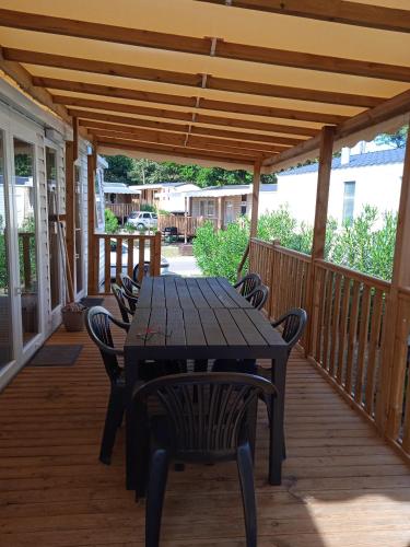 une table et des chaises en bois sur une terrasse dans l'établissement les viviers, à Lège-Cap-Ferret