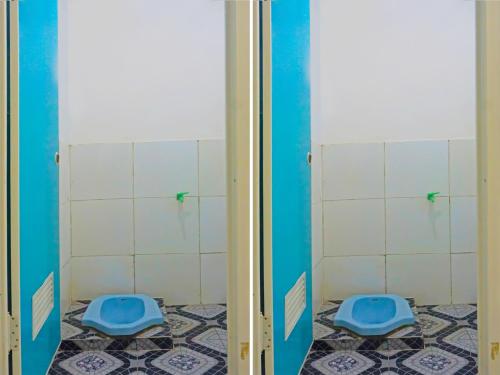 2 aseos en un baño con azulejos azules y blancos en SPOT ON 92154 Nusasari Guest House, en Sukabumi