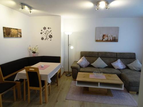 ein Wohnzimmer mit einem Sofa und einem Tisch in der Unterkunft Appartementhaus Bayern Residenz in Bad Füssing