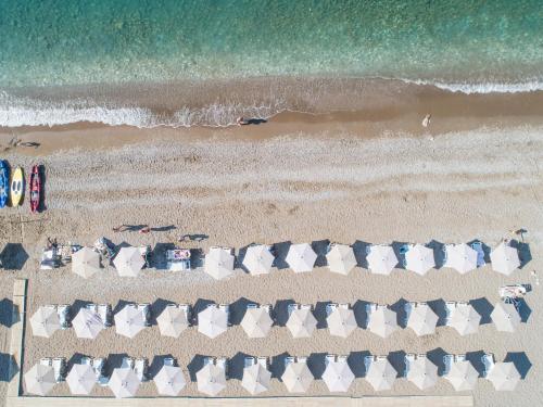 uma vista sobre uma praia com cadeiras e o oceano em Hotel Monte Mare - all inclusive em Čanj